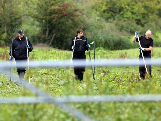 Police officers searching a field at Cariad Farm, Peterstone Wentloog, Gwent