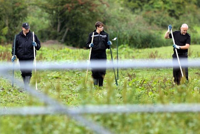 Police officers searching a field at Cariad Farm, Peterstone Wentloog, Gwent