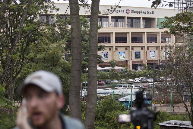 A reporter films while a bout of heavy gunfire takes place shortly after dawn at the Westgate Mall in Nairobi, Kenya