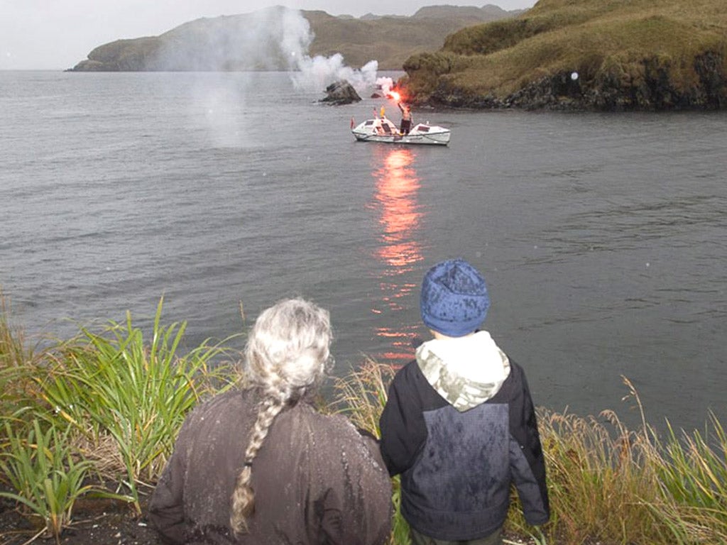 Onlookers watch Outen wave a flare upon arrival in Adak, Alaska