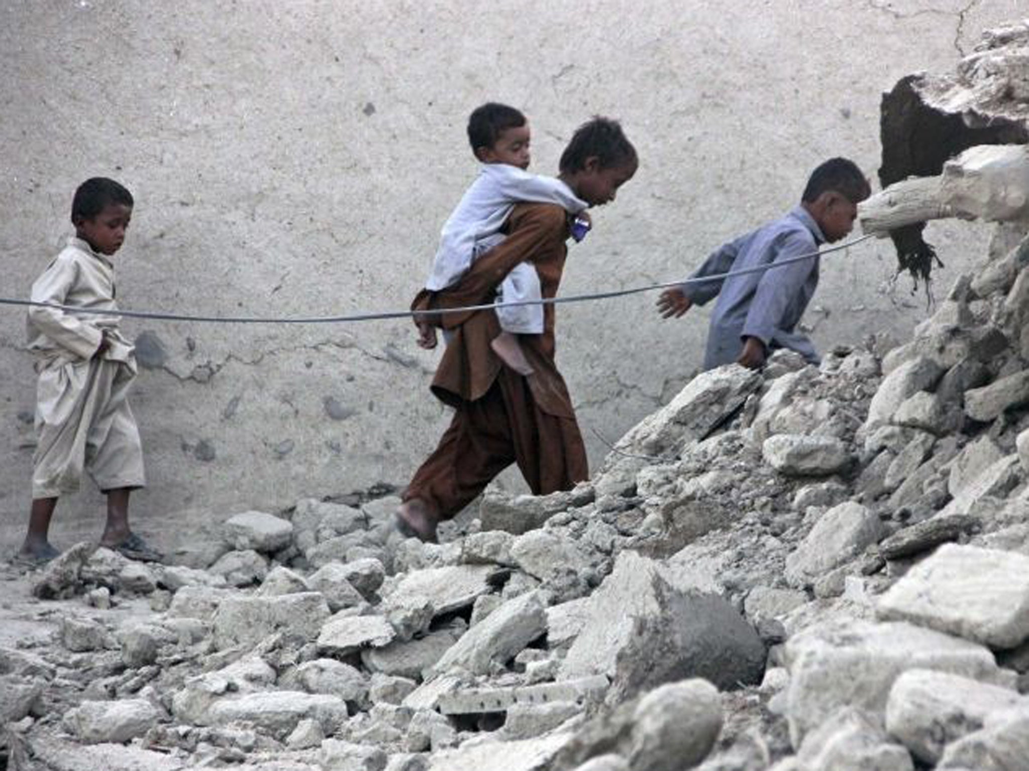 Survivors walk among the rubble in Awaran