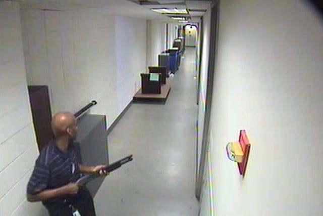 A handout surveillance image released by the Federal Bureau of Investigation (FBI) on 25 September 2013 showing Aaron Alexis in the hallway of building #197 carrying a Remington shotgun as his rampage began in Washington