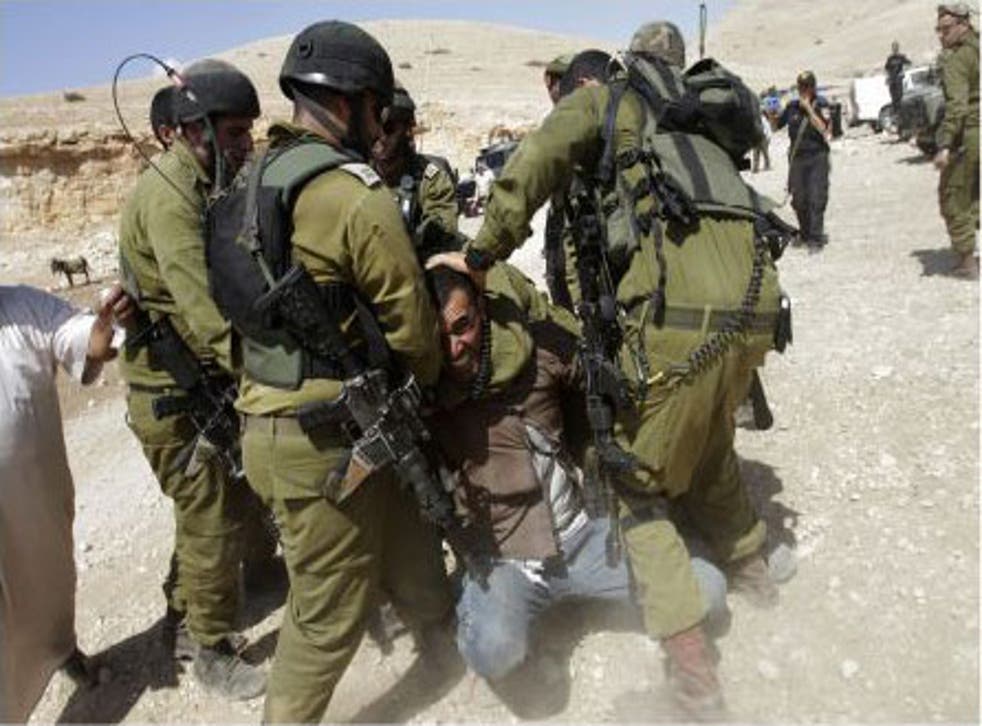 Israeli soldiers detain a Palestinian man after an attempt by EU diplomats to deliver aid to Palestinians remaining in Makhul