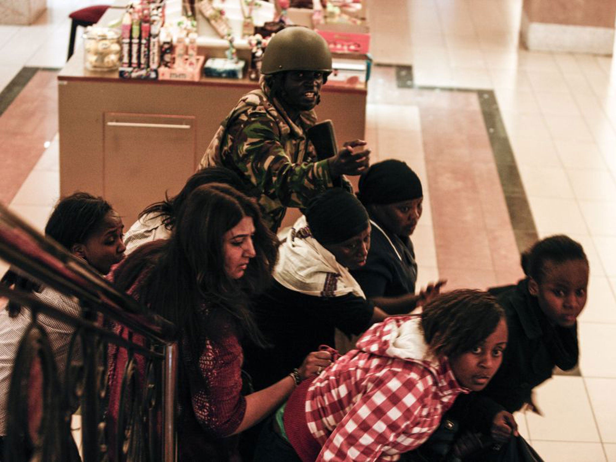 A soldier helps people inside Westgate mall on Saturday