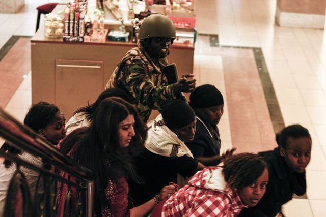 A soldier helps people inside Westgate mall on Saturday