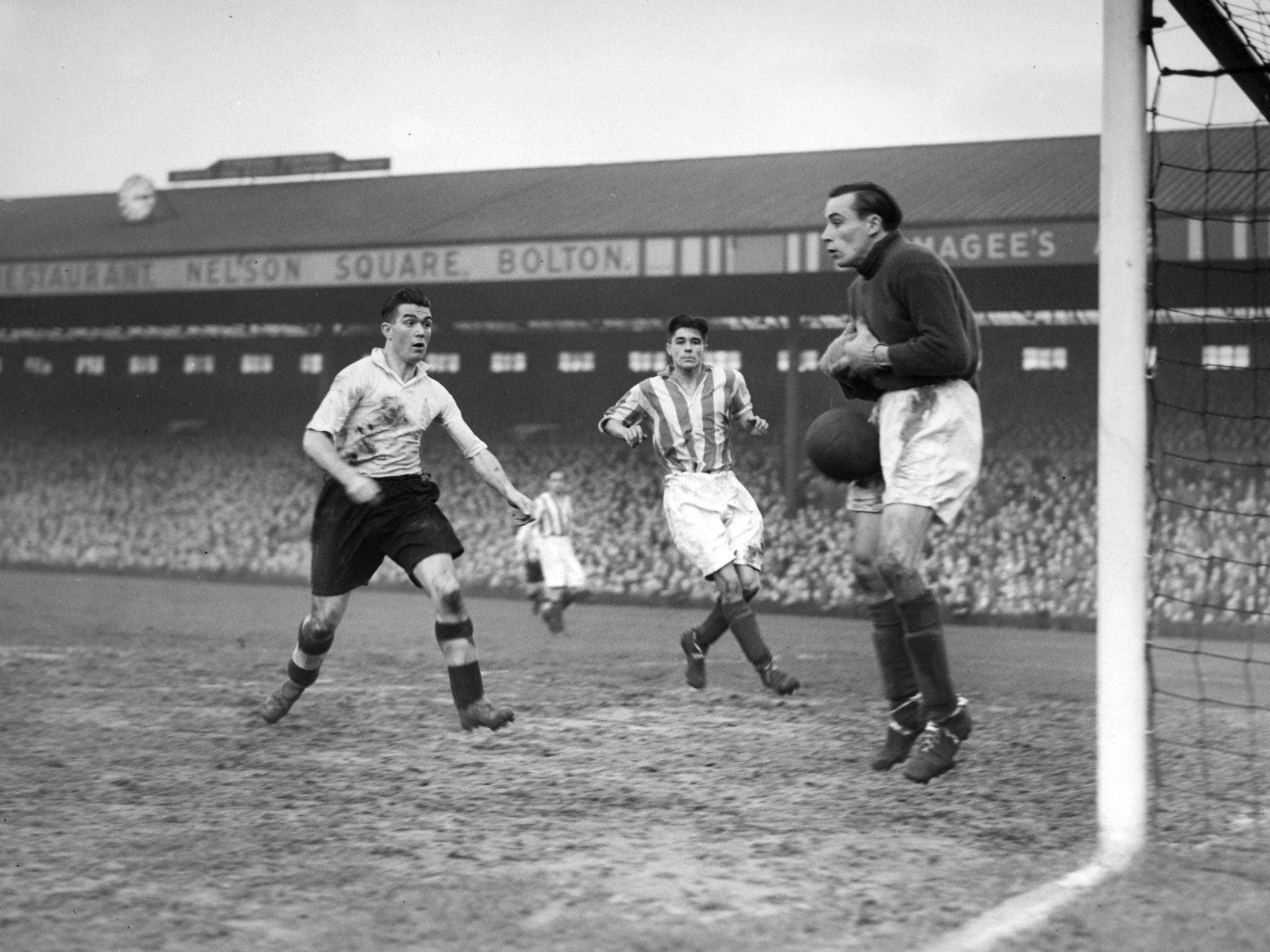 Barrass, left, goes goal-poaching as the Stoke goalkeeper Dennis Herod fumbles the ball in August 1948