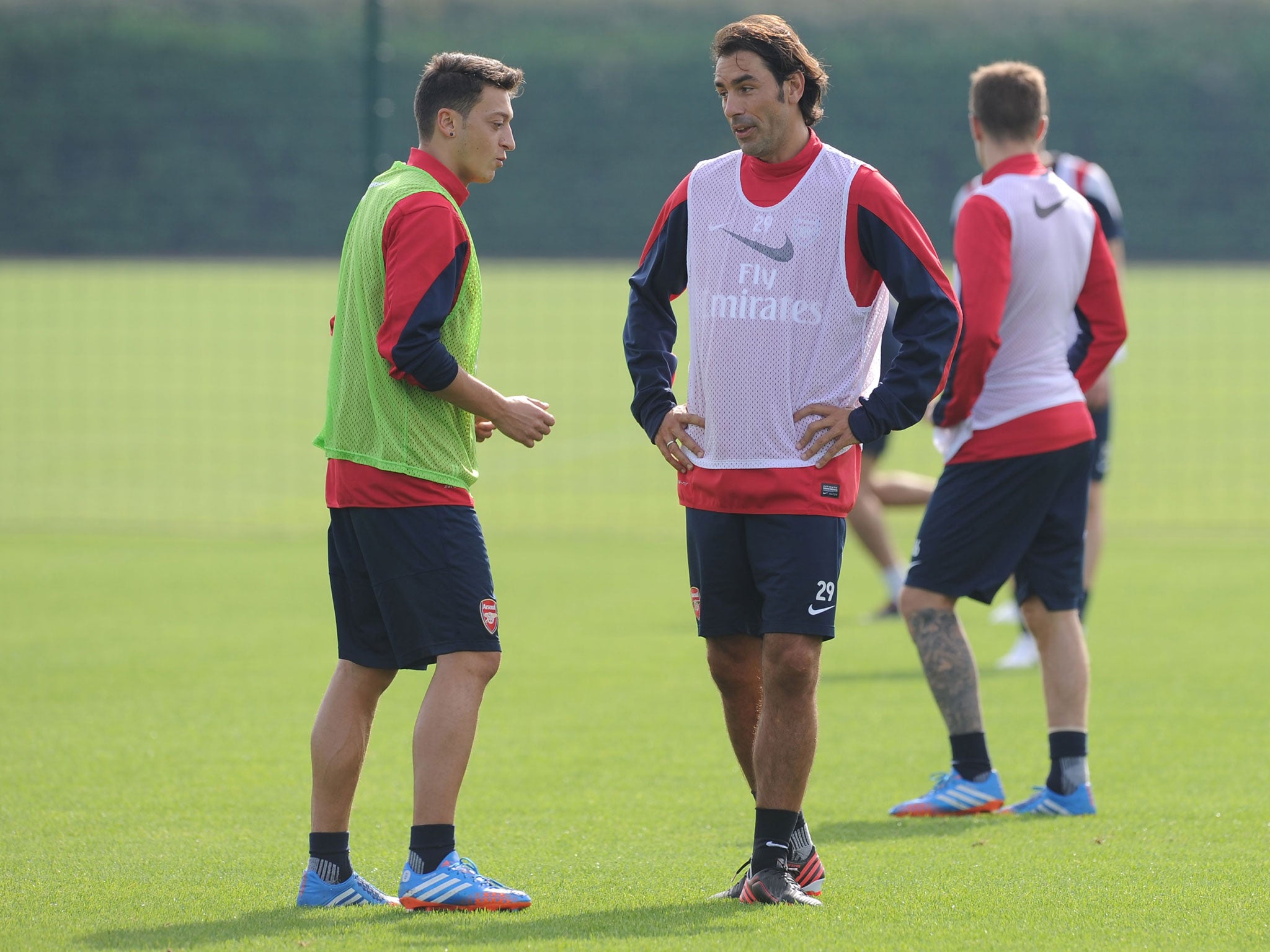 Mesut Ozil and Robert Pires have a chat during Arsenal training