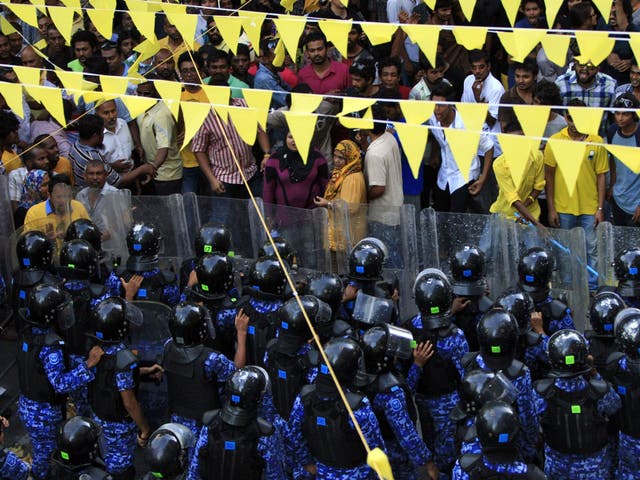Supporters of former president Mohamed Nasheed face police officers during a protest demanding that election be held as scheduled Saturday