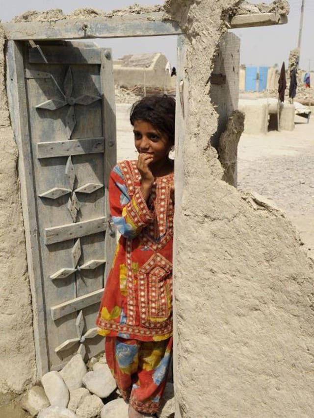 A Pakistani earthquake survivor stands in the doorway of a damaged house in the devastated district of Awaran on September 25, 2013. A powerful 6.8-magnitude earthquake hit southwest Pakistan, in a region already devastated by a tremor which left more tha