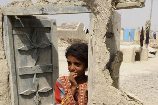 A Pakistani earthquake survivor stands in the doorway of a damaged house in the devastated district of Awaran on September 25, 2013. A powerful 6.8-magnitude earthquake hit southwest Pakistan, in a region already devastated by a tremor which left more tha