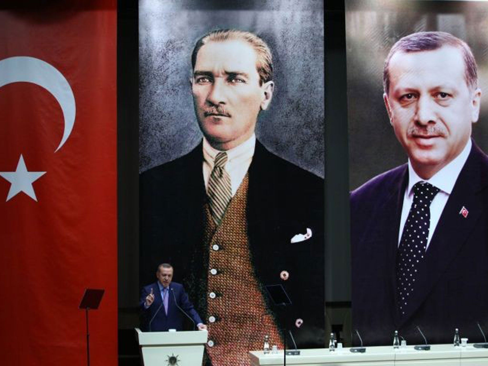 Past glory: Erdogan speaks, backed by portraits of himself and Ataturk, earlier this month