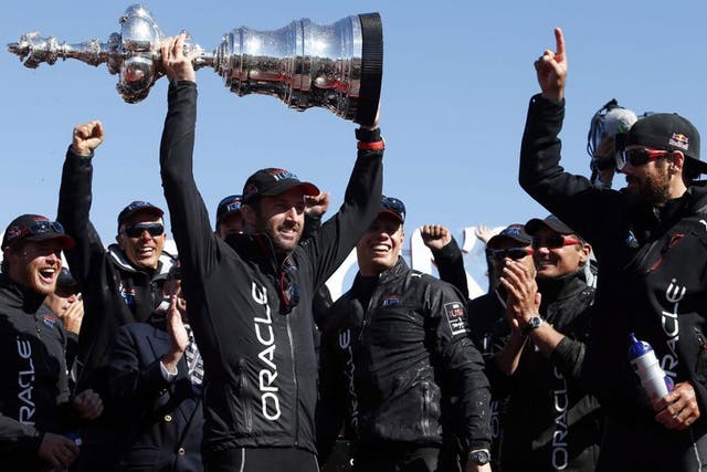 Ben Ainslie collects the mammoth Americas Cup trophy