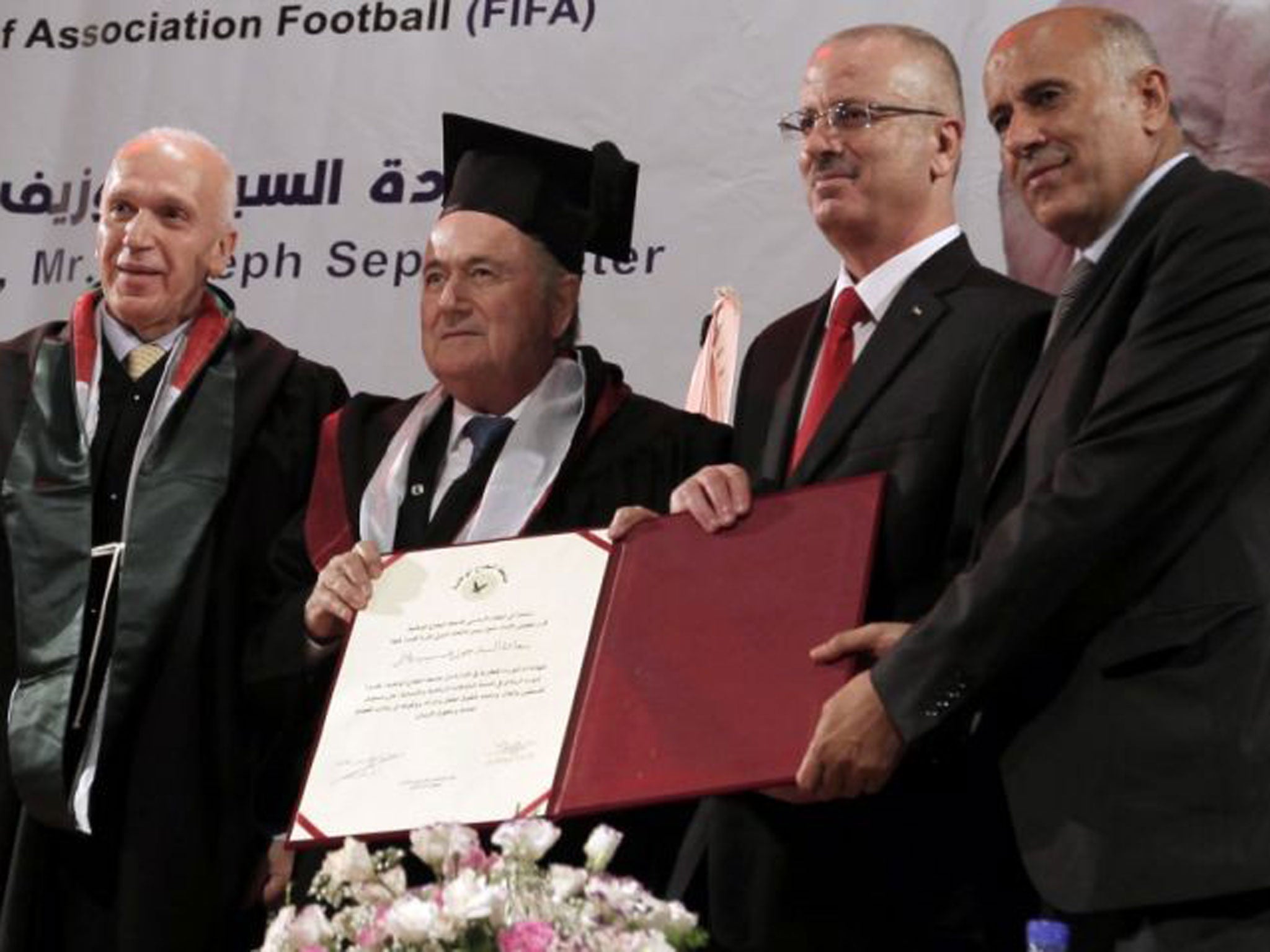 Bitter pill: Sepp Blatter receives an honorary doctorate from Palestinian prime minister Rami Hamdallah; he boasts of being ‘humanitarian of the year’