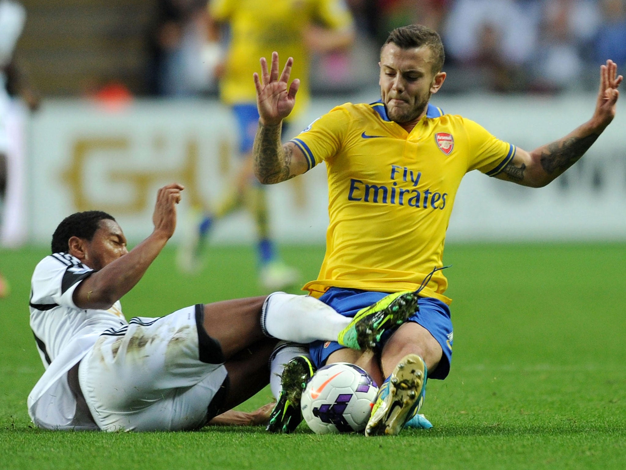 Jack Wilshere dives in on Jonathan De Guzman during Arsenal's clash with Swansea