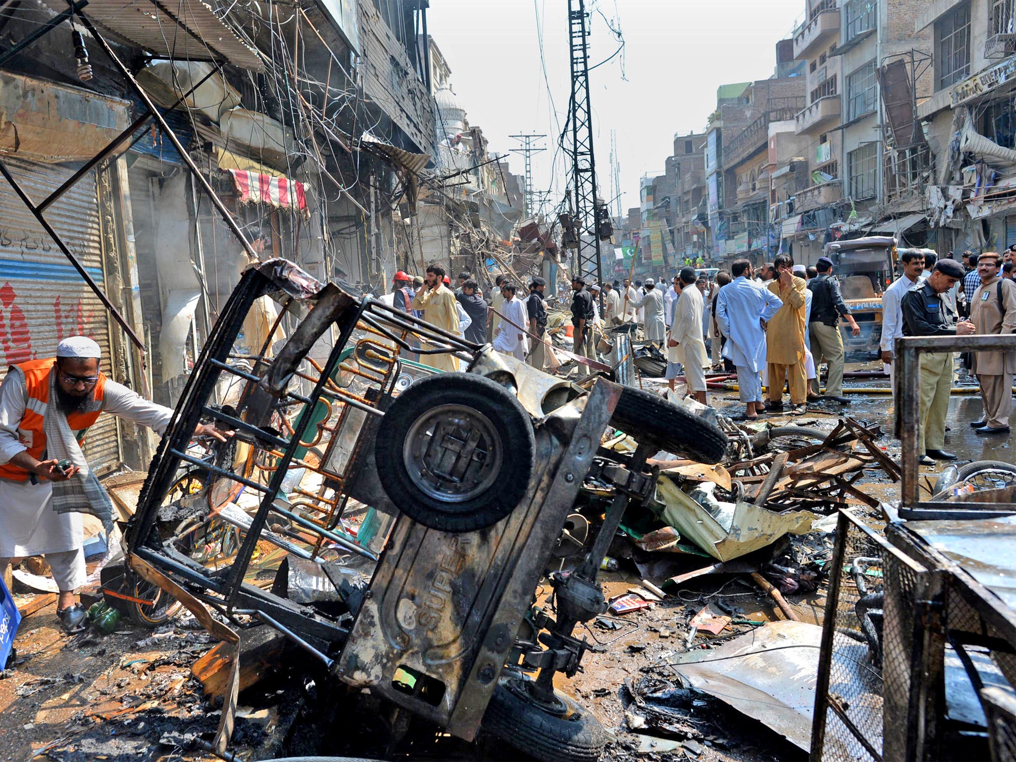 A Pakistani volunteer searches the bomb scene (Getty)