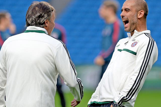 Pep Guardiola shares a joke with one of his coaches during training at the Etihad Stadium