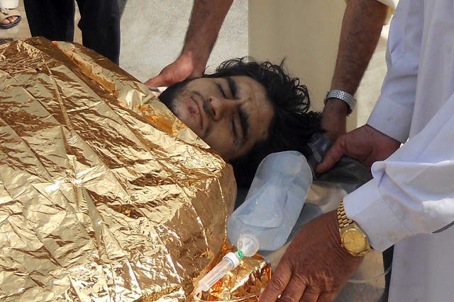 Pakistani men carry an injured bombing victim into a hospital in Hangu
