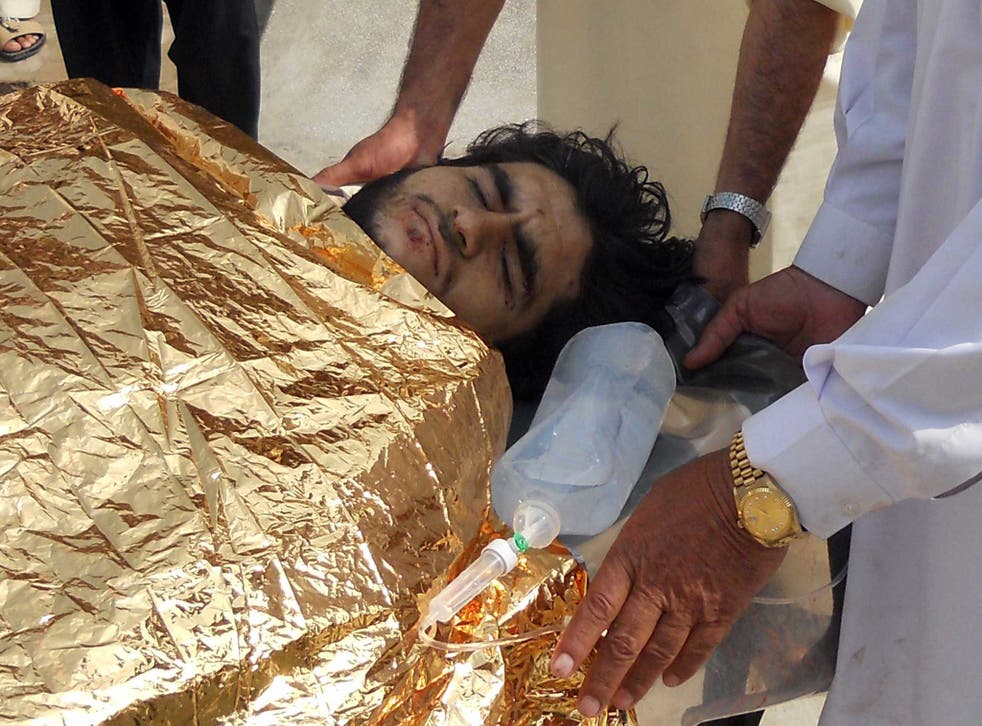 Pakistani men carry an injured bombing victim into a hospital in Hangu