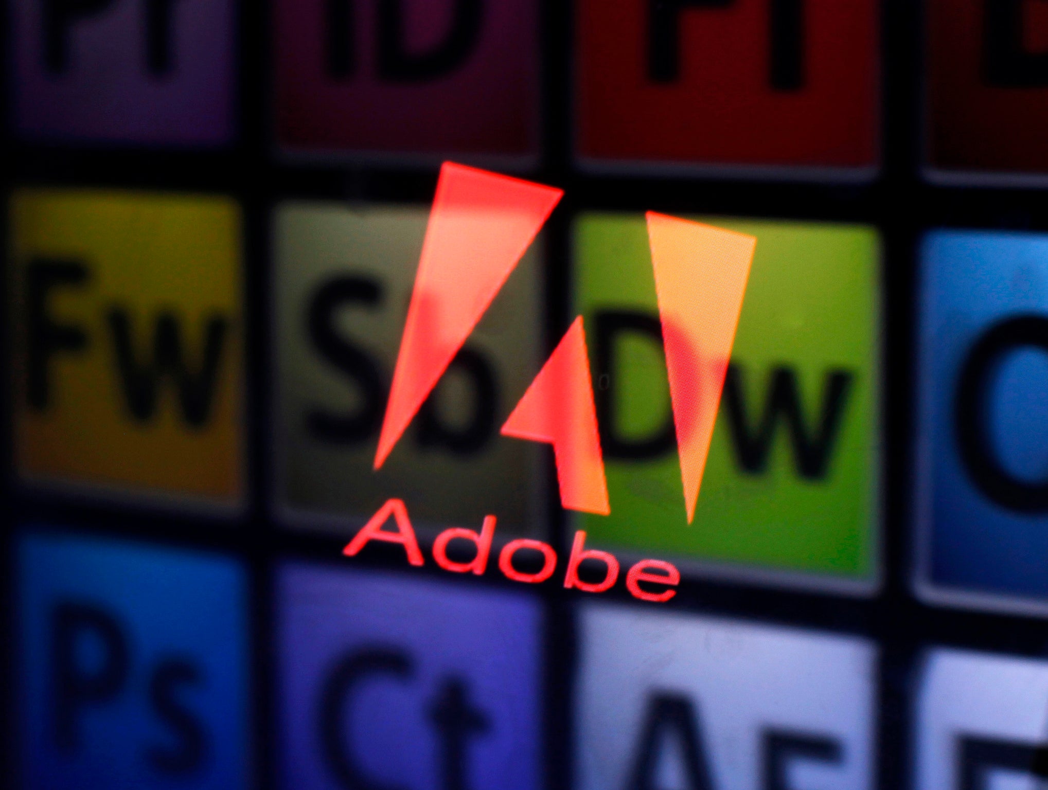 2013An Adobe logo and Adobe products are seen reflected on a monitor display and an iPad screen.