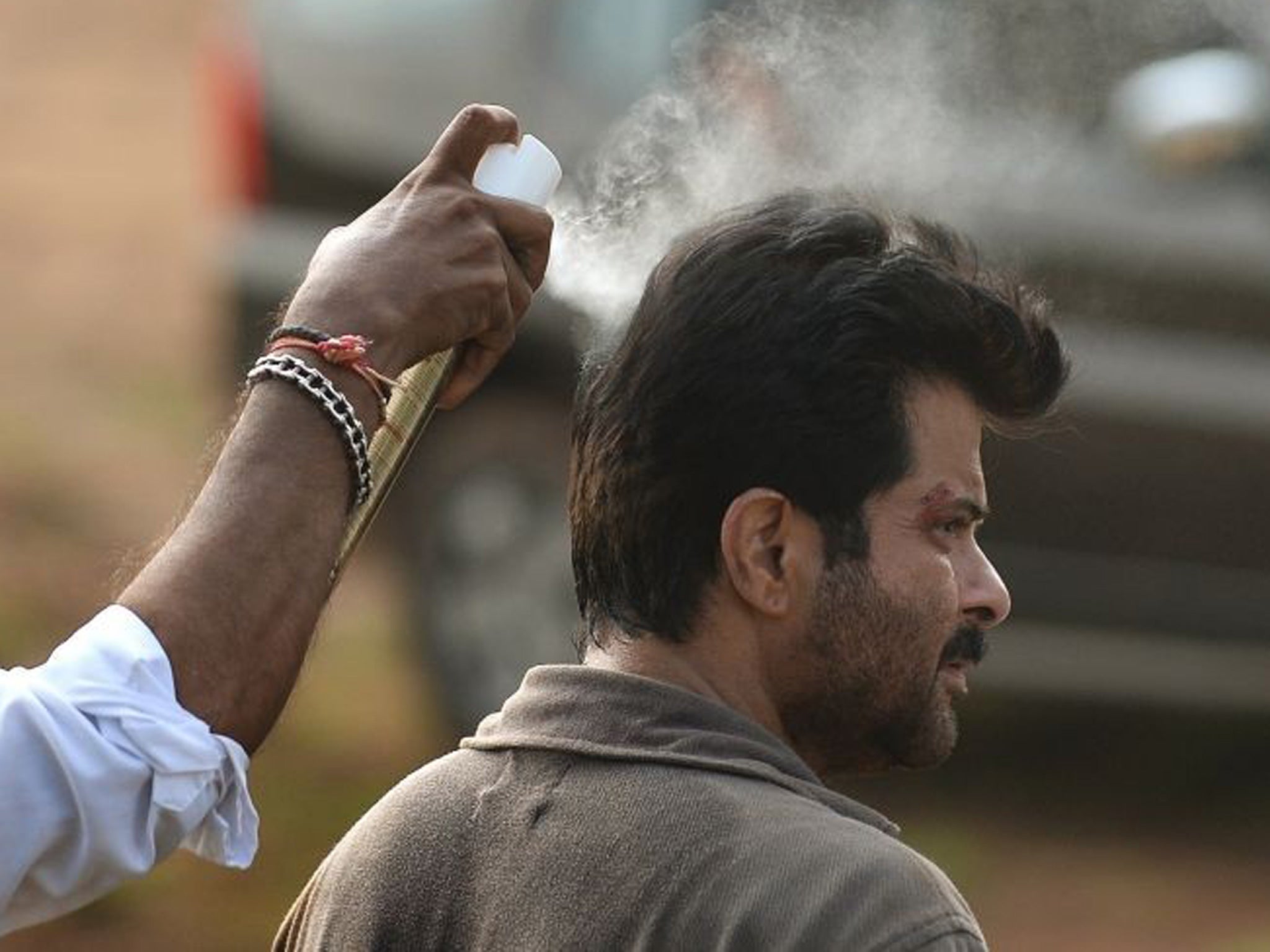 Indian Bollywood actor Anil Kapoor has hairspray applied during shooting for the new television show '24' on location on a film set in Mumbai