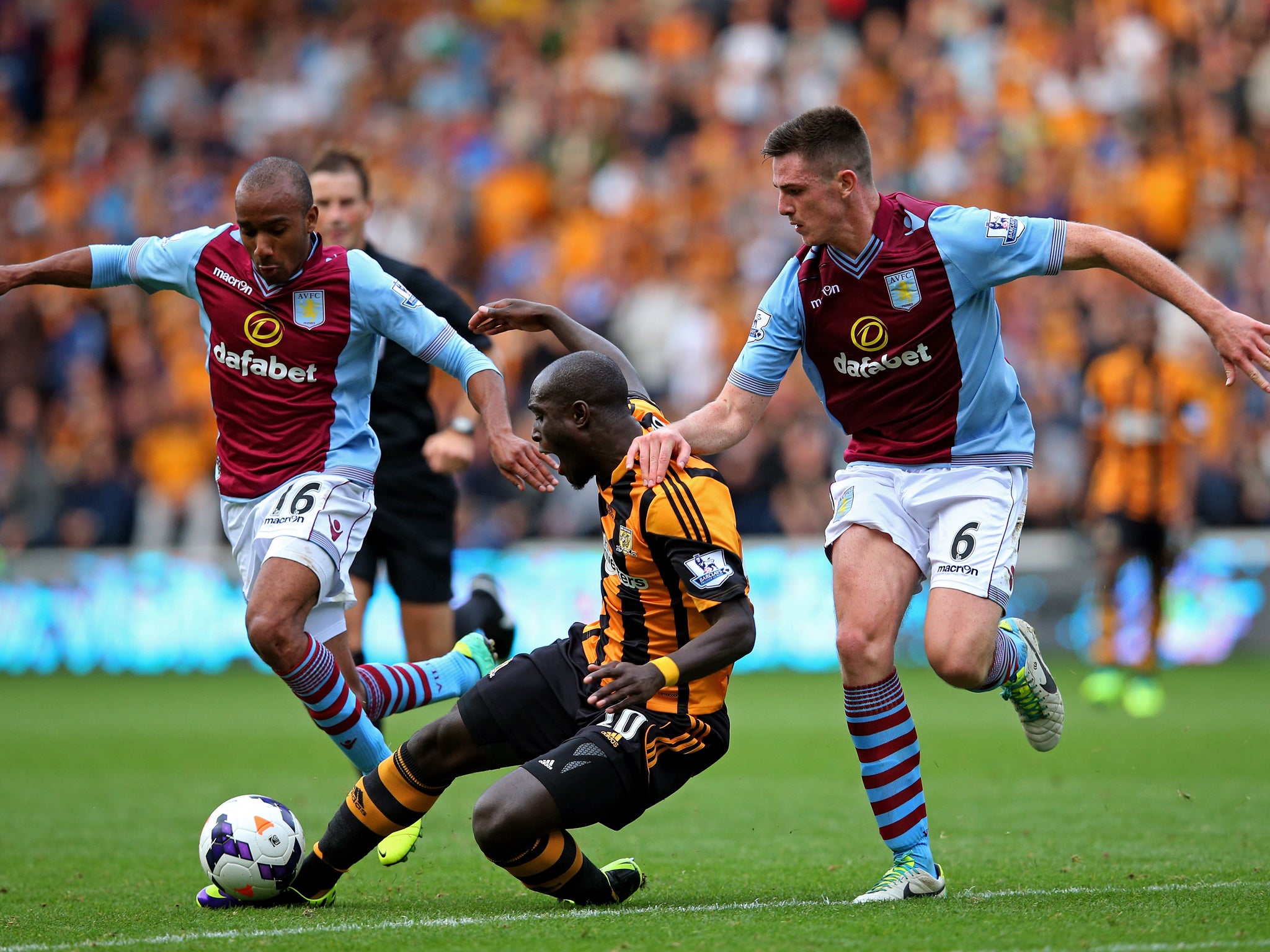 Yannick Sagbo of Hull is tackled by Fabien Delph and Ciaran Clark of Aston Villa