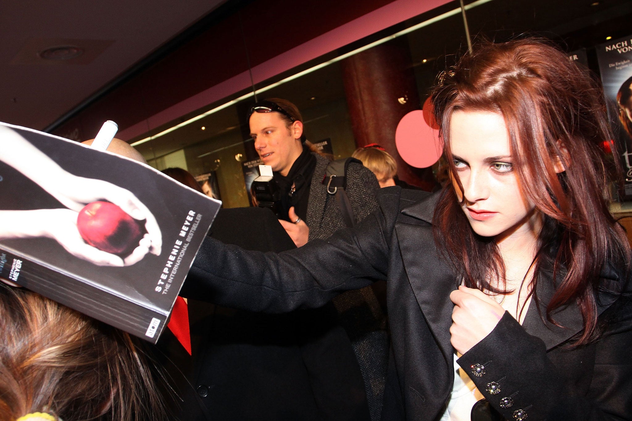 Acress Kristen Stewart signs a fan's copy of Twilight