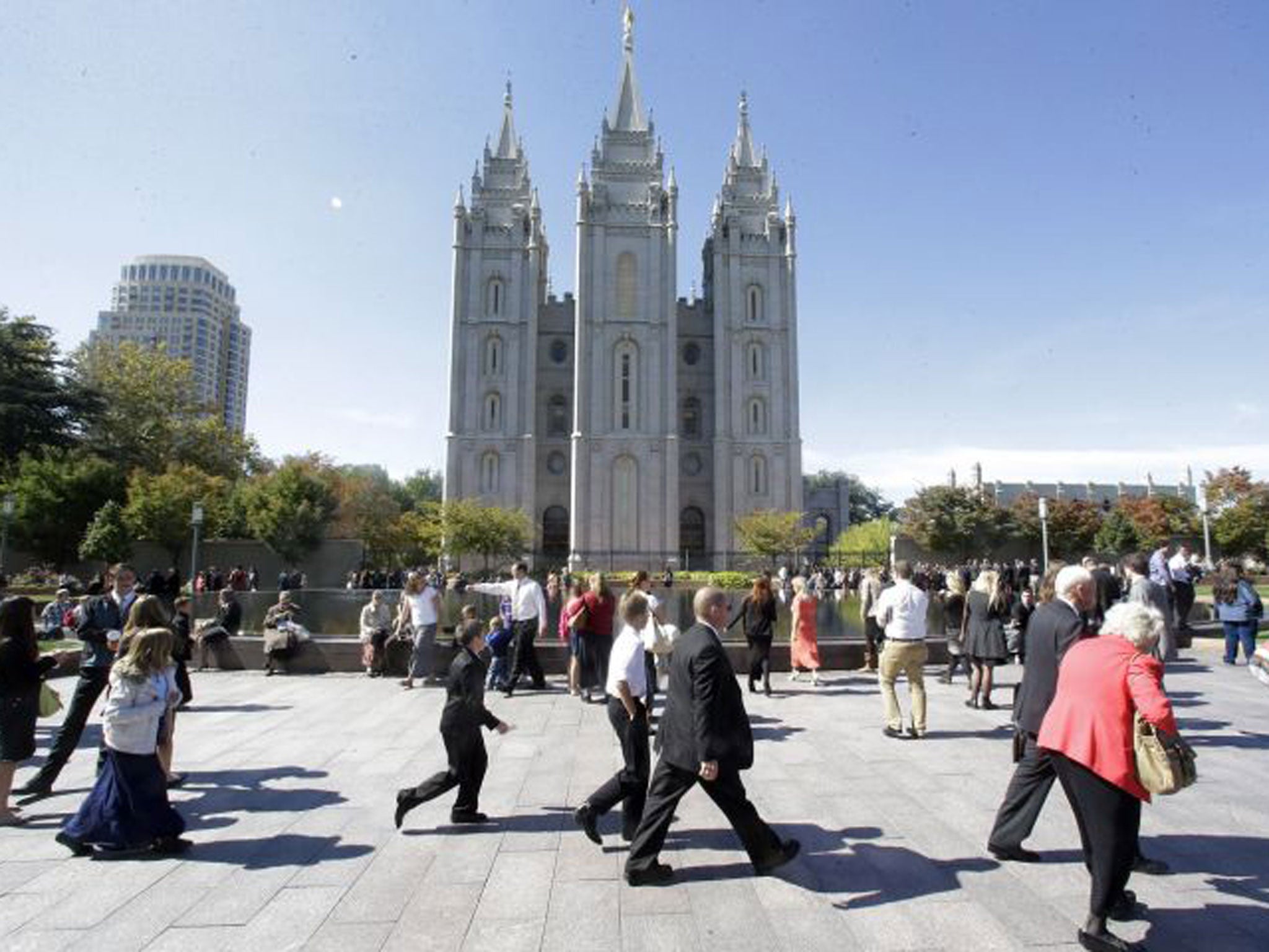 Believers walk past Salt Lake Temple ahead of the Church of Jesus Christ of Latter-Day Saints’ biannual meeting in Salt Lake City