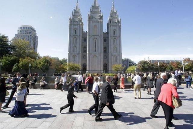 Believers walk past Salt Lake Temple ahead of the Church of Jesus Christ of Latter-Day Saints’ biannual meeting in Salt Lake City