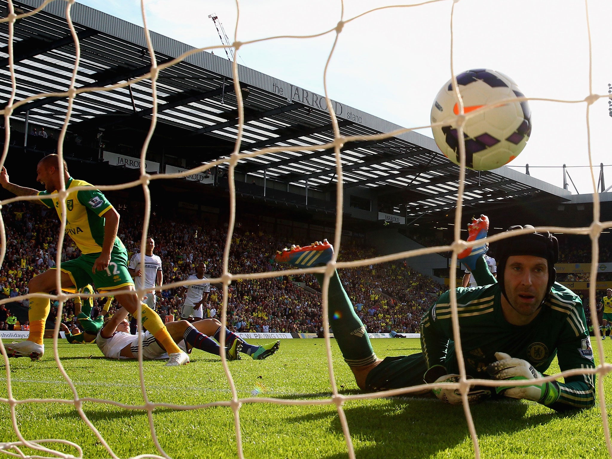Anthony Pilkington of Norwich City turns to celebrate his goal as Petr Cech of Chelsea watches the ball go into the net during the Barclays Premier League match between Norwich City and Chelsea