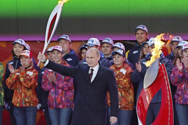 Vladimir Putin with the Olympic torch at a ceremony in Moscow yesterday