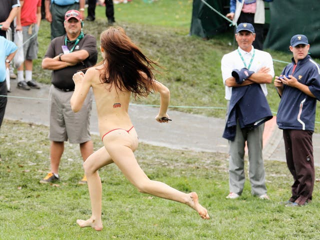 U.S Team captain Fred Couples looks on as the streaker sprints past him, much to his bemusement