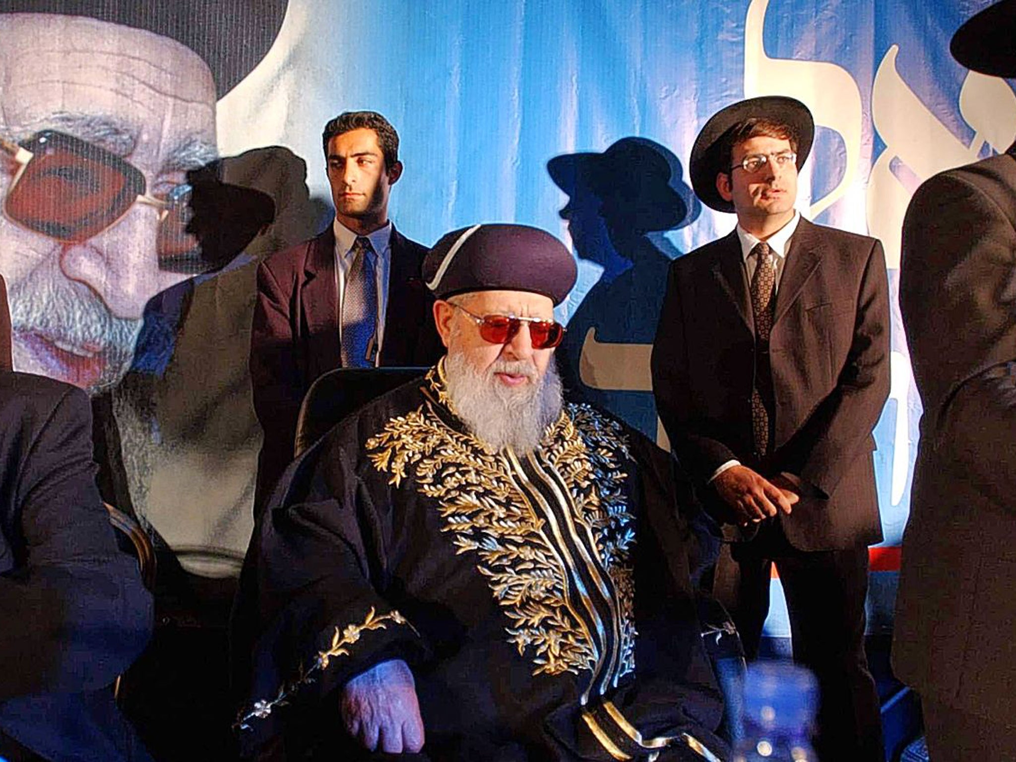 Yosef sits surrounded by Shas staff at a rally in 2002; he retained control over all party decisions