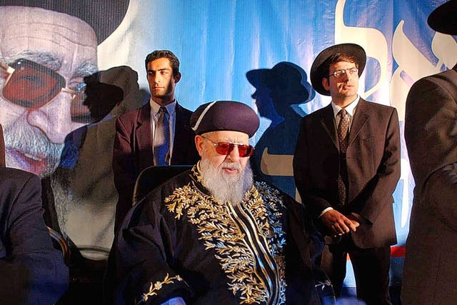Yosef sits surrounded by Shas staff at a rally in 2002; he retained control over all party decisions