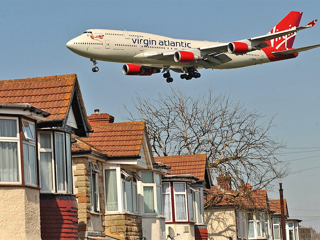 A passenger jet flies over houses near Heathrow airport (Getty)