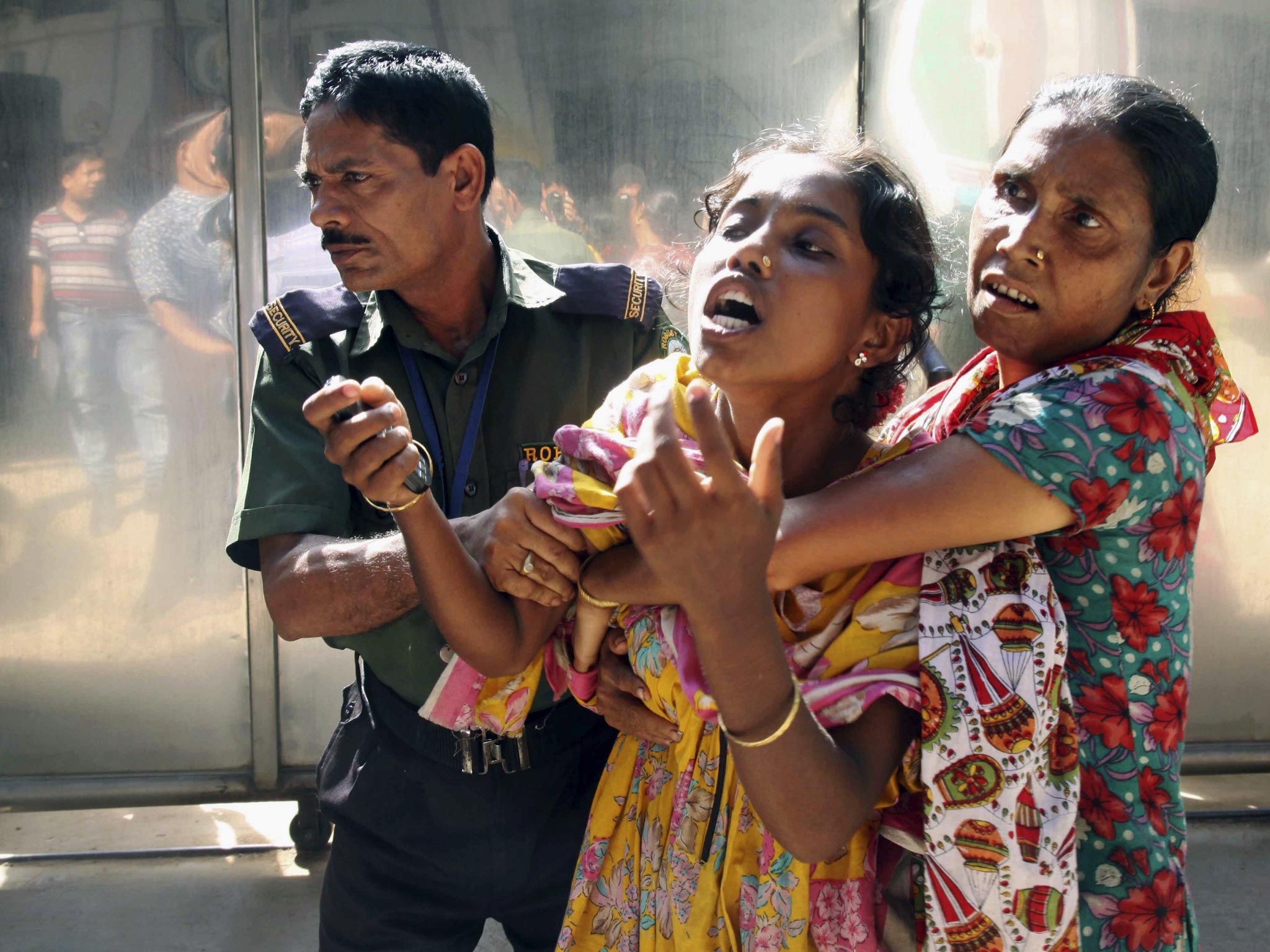 The relative of a Bangladeshi garment factory worker cries at the scene of a factory fire (Reuters)