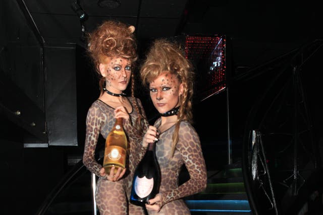 Waitresses at Kitsch nightclub hold bottles of champagne