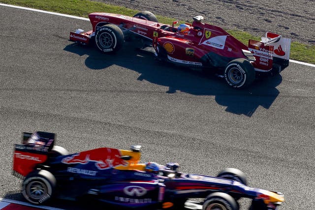 Sebastian Vettel (bottom) drives past Fernando Alonso, who is facing the wrong way after spinning during practice
