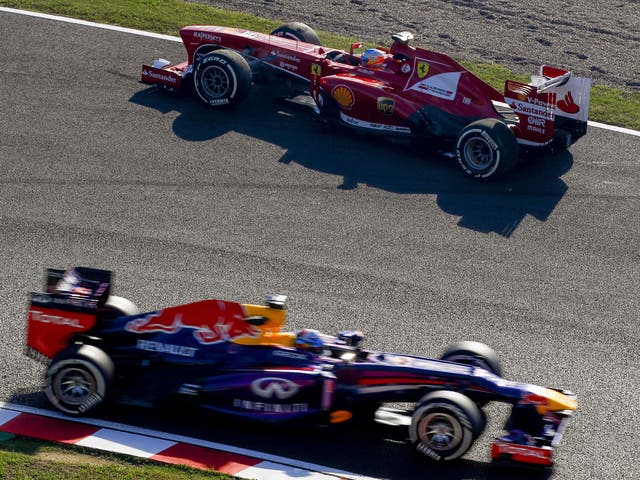 Sebastian Vettel (bottom) drives past Fernando Alonso, who is facing the wrong way after spinning during practice