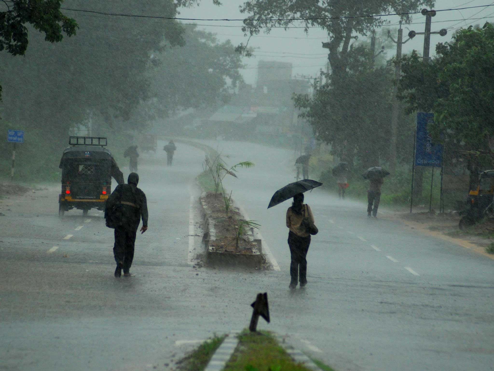 Indians return to their homes during a heavy cyclone rain in Berhampur city