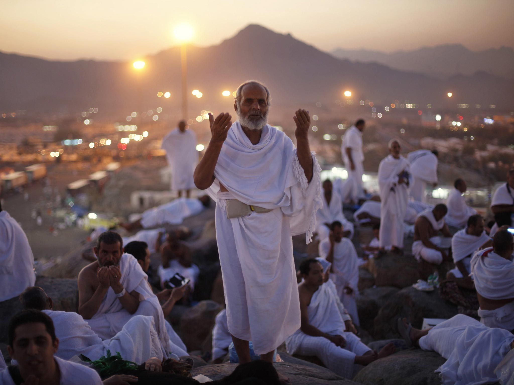 14 October 2013: A Muslim pilgrim prays atop Mount Mercy on the plains of Arafat during the peak of the annual haj pilgrimage, near the holy city of Mecca early morning