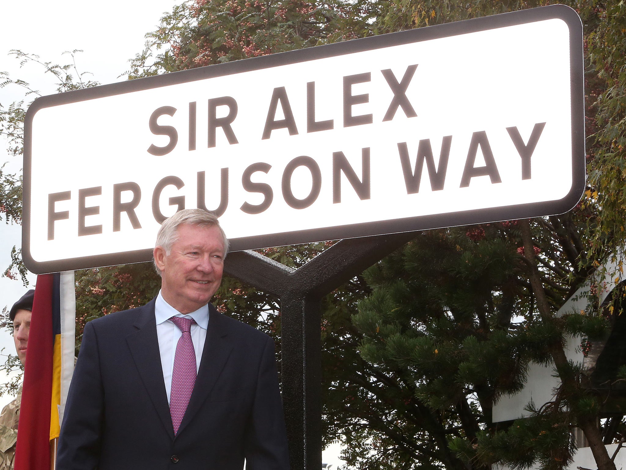 Sir Alex Ferguson poses with the street sign