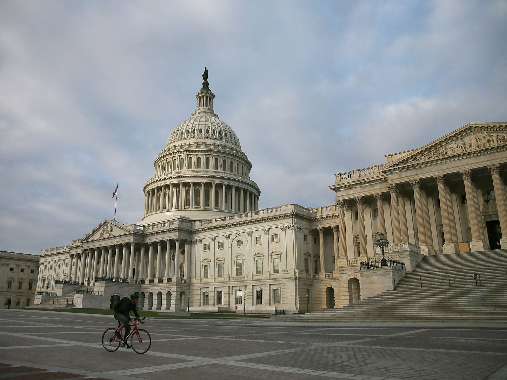 A cyclist rides past the US Capitol