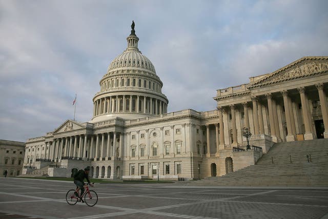 A cyclist rides past the US Capitol