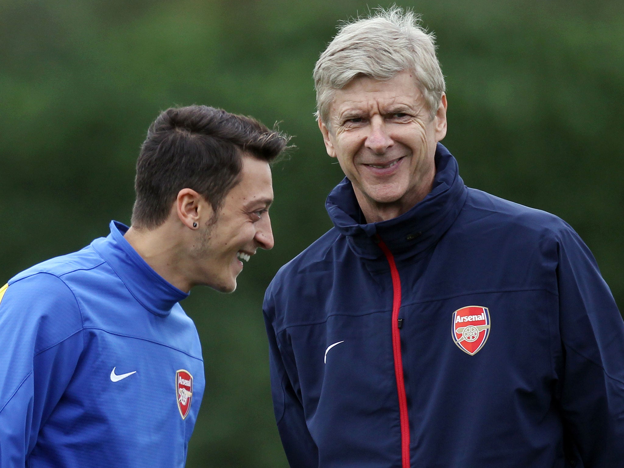 Mesut Ozil (left) and Arsene Wenger share a joke in training
