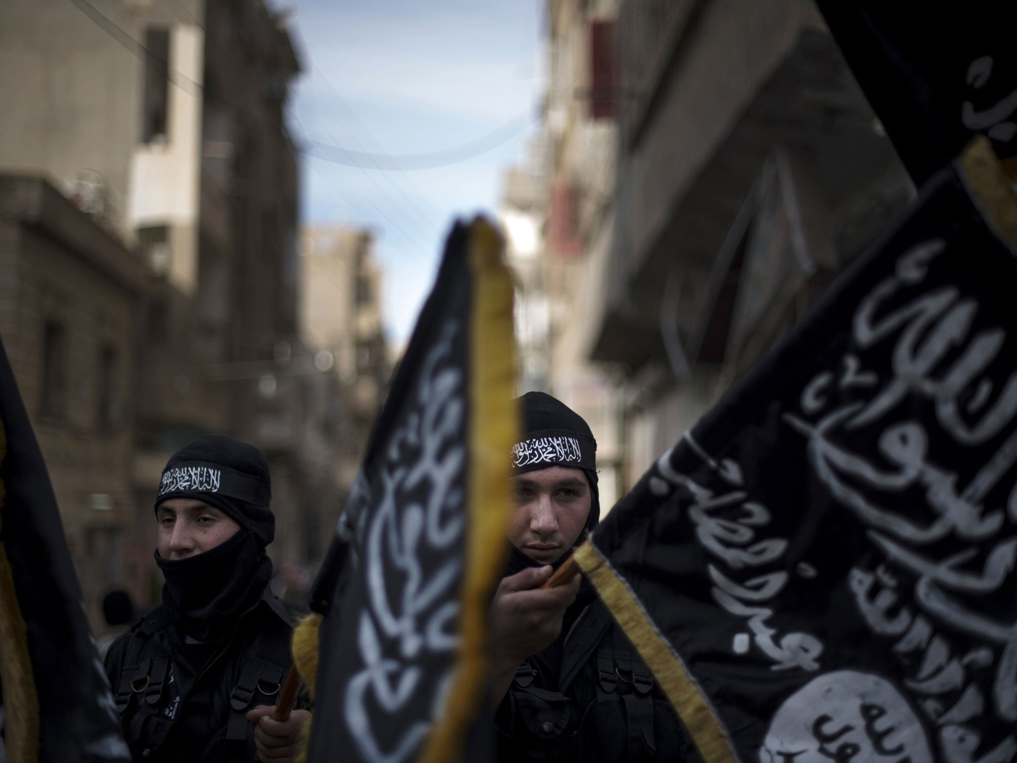 Members of the Islamist Liwa (brigade) Hamzah hold flags of Jebhat al-Nusra at a rally in Deir Ezzor earlier this year