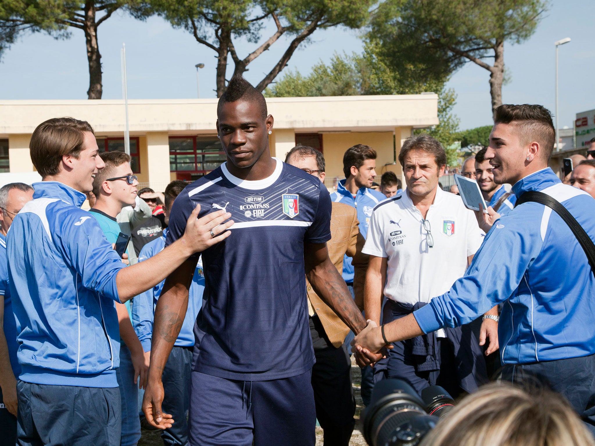 Mario Balotelli is greeted by Italian supporters ahead of their training session in Quarto