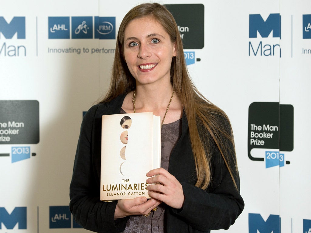 New Zealand author Eleanor Catton poses with her book 'The Luminaries'