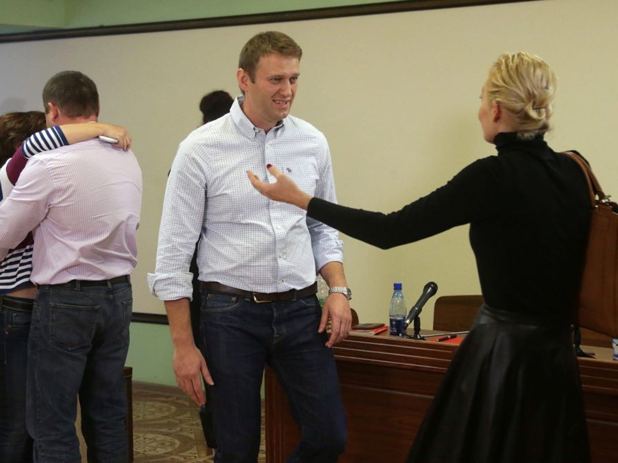 Russian opposition leader Alexey Navalny (centre), his wife Yulia (R) react in court