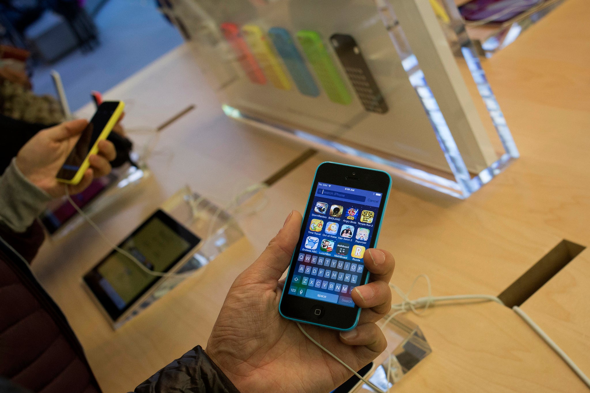 A customer looks at an Apple iPhone 5C at the Apple Retail Store on Fifth Avenue in Manhattan, New York September 20, 2013.