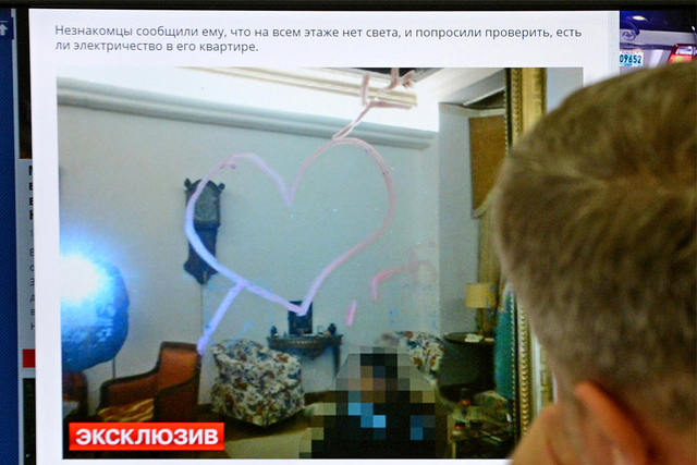 A man looks at a computer screen displaying a photo of a mirror with a drawing of a heart and the letters LGBT (standing for lesbian, gay, bisexual and transgender) left by unknown individuals who broke into the flat of Onno Elderenbosch